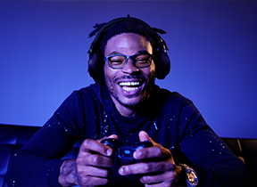 person playing video games wearing blue light blocking glasses